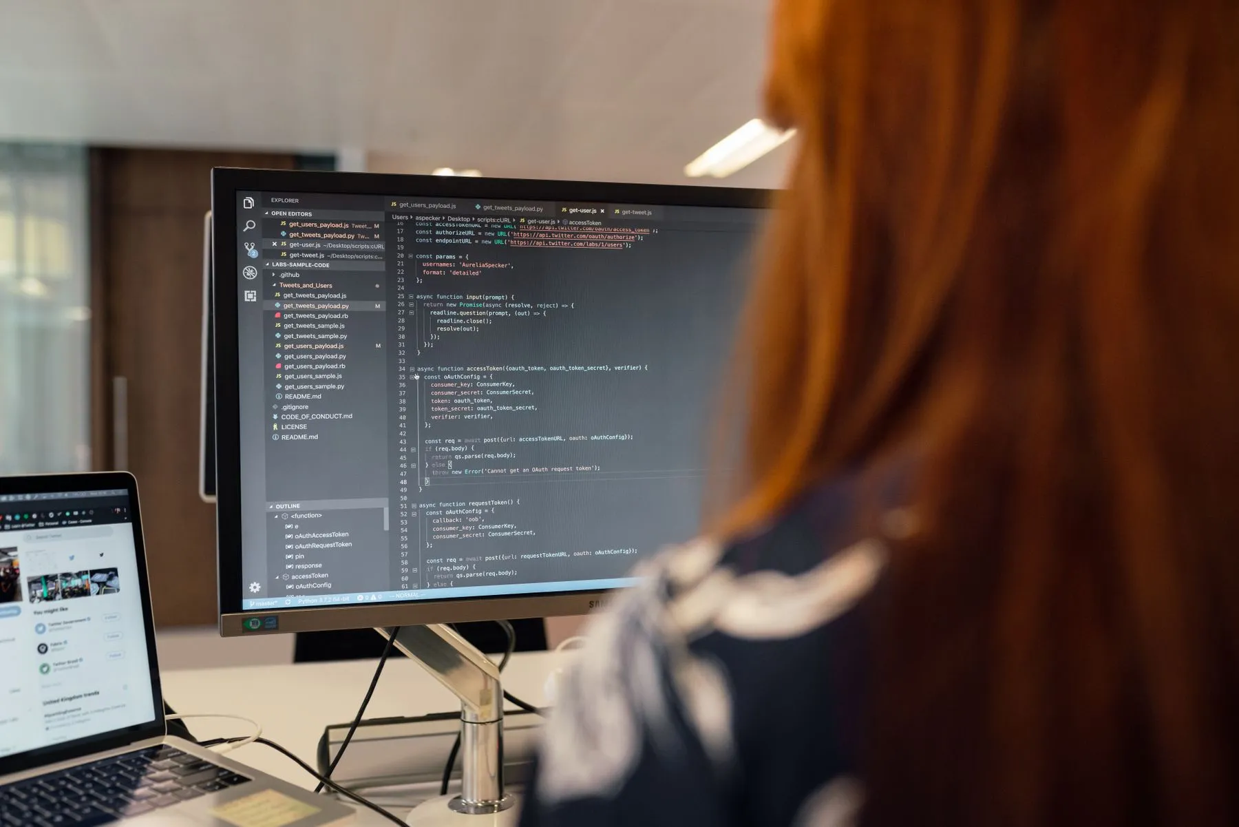 Engenheira de software revisando código em um monitor