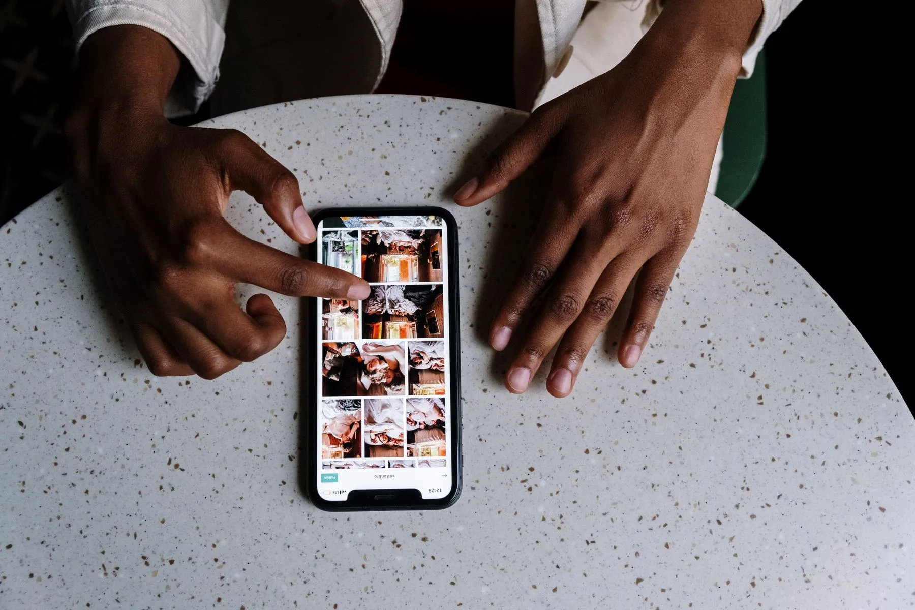Mãos usando um smartphone com uma grade de publicações